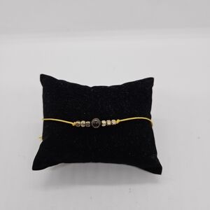 yellow drawstring bracelet with gold tone and brown beads